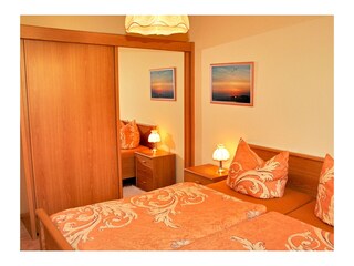 Schlafzimmer mit Doppelbett und Kleiderschrank