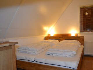 Schlafzimer mit Doppelbett und Kommode
