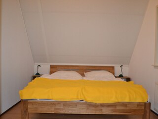 Elternschlafzimmer mit Doppelbett und Spiegelschrank