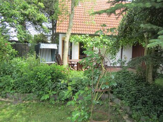 Uriger Garten mit gemütlicher Sitzecke und Strandkorb