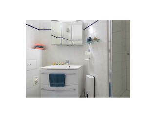 Badezimmer mit Toilette, Waschbecken und Spiegelschrank