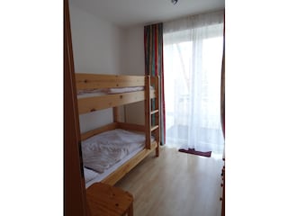 Schlafzimmer mit Etagenbett und Kommode