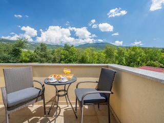 Terrasse des Zimmers mit Blick auf die Berge &Pool