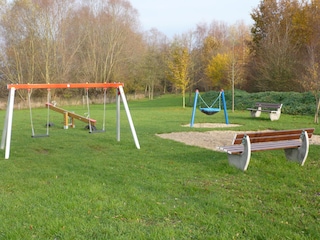 Spielplatz mit Schaukel, Wippe und Tischtennisplatte