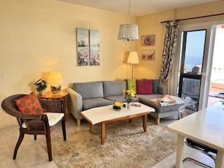 Wohnzimmer mit großer Glastüre zur Terrasse / Meer