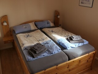 Im separatem Schlafzimmer steht ein großes Doppelbett