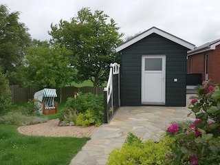 Blick auf den Garten mit Abstellraum für Fahrräder