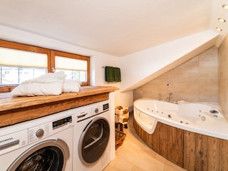 Badezimmer mit Whirlwanne und Waschmaschine/Trockner