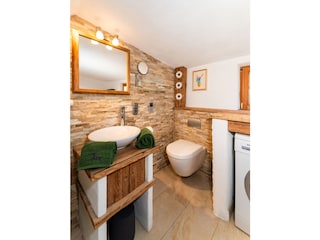 Badezimmer mit Waschtisch, WC und Fußbodenheizung