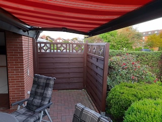 Terrasse mit Markise und Gartenmöbeln