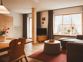 Großer Wohnraum mit Sofa, Essecke und Doppelbett