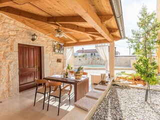 überdachte Terrassensitzgruppe mit Blick zum Poolbereic