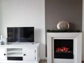 Fernseher und Kamin im Wohnzimmer Woogehus