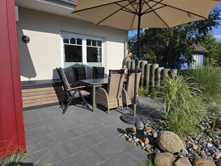 Terrasse mit Gartenmöbeln, Sonnenschirm, Grill