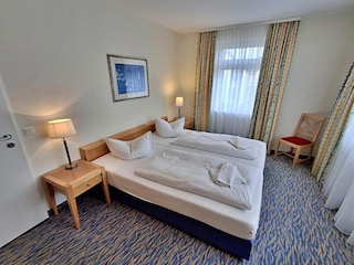 Schlafzimmer mit Doppelbett und Kleiderschrank