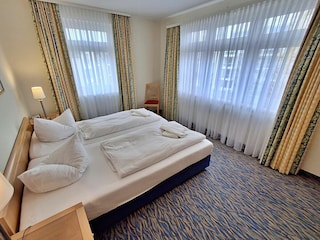 Schlafzimmer mit Doppelbett und Kleiderschrank