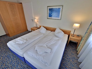 Schlafzimmer mit Doppelbett und Kleiderschrank