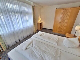 Schlafzimmer mit Doppelbett und Kleiderschrank