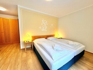 1. Schlafzimmer mit Doppelbett und zusätzlichem TV