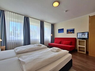 Schlafzimmer mit Doppelbett und Wohn- und Schlafcouch