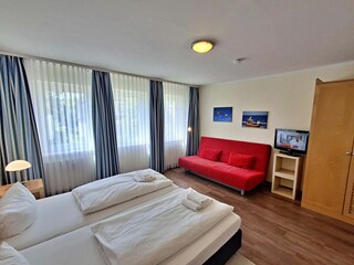 Schlafzimmer mit Doppelbett und Wohn- und Schlafcouch