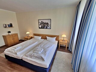 Schlafzimmer mit Doppelbett und Wohn- und Schlafcouch