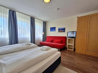 Schlafzimmer mit Doppelbett und Wohn- und Schlafcouch