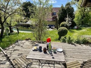 Südterrasse im Garten mit Schwimmteich im Hintergrund