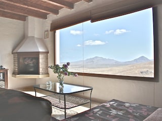 Wohnzimmer mit Panoramafenster und Weitblick auf Berge
