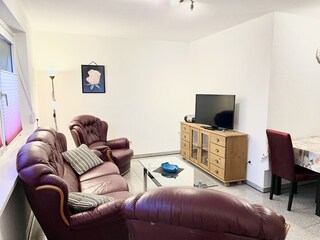 Wohnzimmer mit Ledercouch und Smart TV