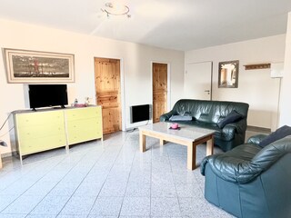 Wohnzimmer mit Ledercouch und Smart TV