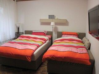 Bedroom with box-spring beds & swivel TV