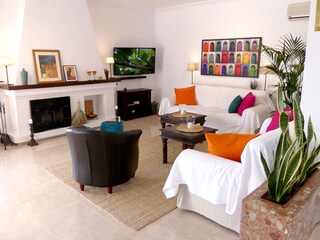 das schöne Wohnzimmer mit TV und Kamin