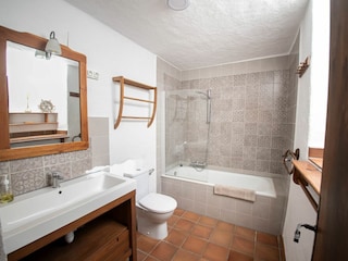 Badezimmer mit Duschbadewanne und WC