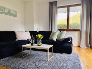 Wohnzimmer mit Sofa & Wein | Blick in den Garten