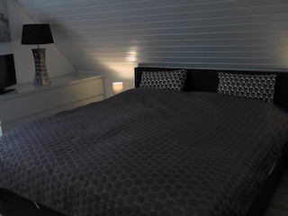 Schlafraum 2 mit Boxspringbett und Fernseher