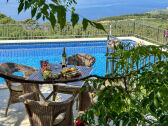 Terrasse am Pool mit Gartenmöbeln und Meerblick