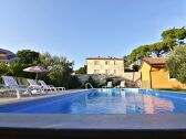 Swimming pool with sun deck, parasols and deck chairs