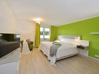 Wohn- und Schlafbereich mit großem TV