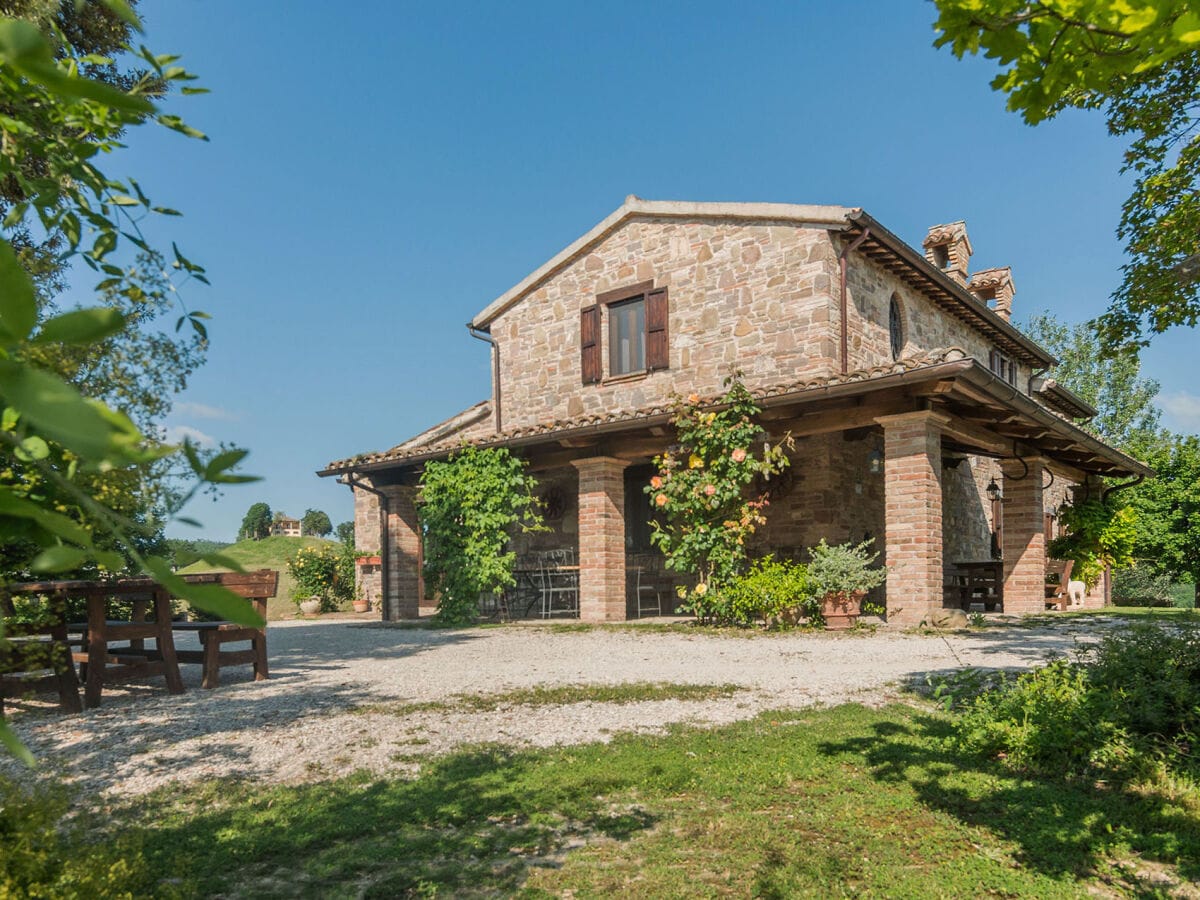 Villa Amata – Veranda mit Tischen, Bänken und Sofas