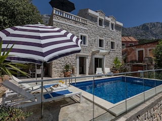 Der Pool mit Sonnenliegen