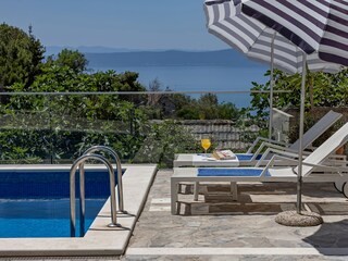 Der Pool mit Sonnenliegen