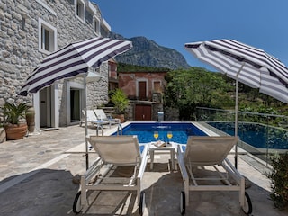 Der Pool mit Sonnenliegen