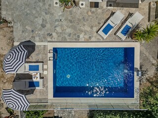 Der Pool mit Sonnenliegen