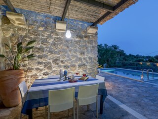 überdachte Terrasse am Pool mit Esstisch