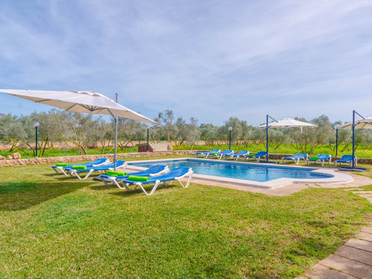 Pool mit Sonnenliegen und Schirmen