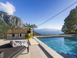 Der Pool mit Meerblick und Sonnenliegen