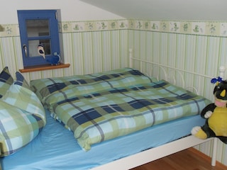 Doppelbett und Kinderbett im Kinderzimmer