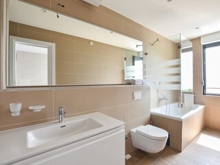 1 von 4 en-suite Badezimmern mit Badewanne, Dusche,