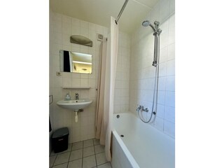 Badezimmer mit Badewanne und Dusche
